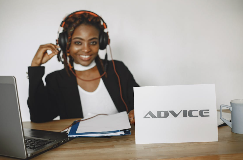 Smiling Woman with an "Advice" Sign Sitting in Front of Her